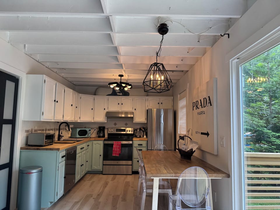 Kitchen: stainless appliances, butcher block counters, air fryer oven, table.