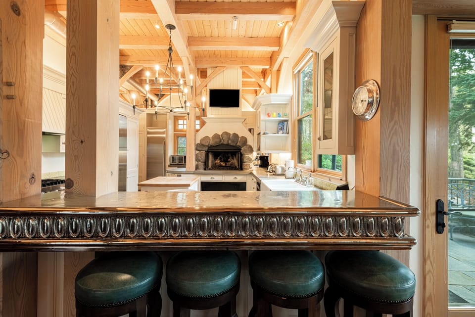 Gourmet Kitchen with Viking appliances, modern stone countertops, butcher block center island, wood burning fireplace, and additional prep kitchenette with private entrance and secondary appliances