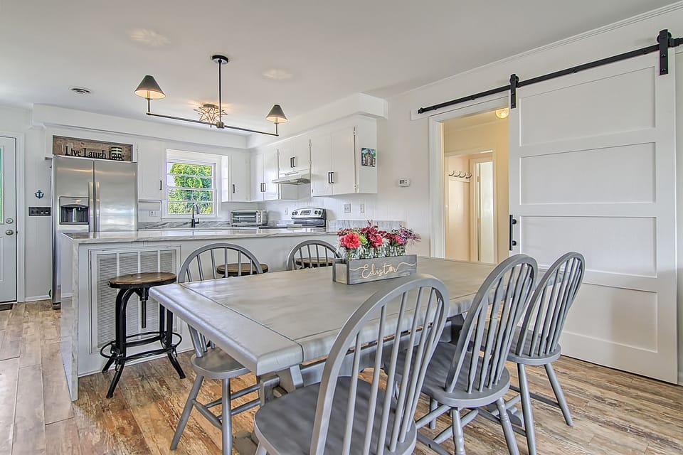 Dining with seating for eight, note barn door for privacy to Queen rooms  