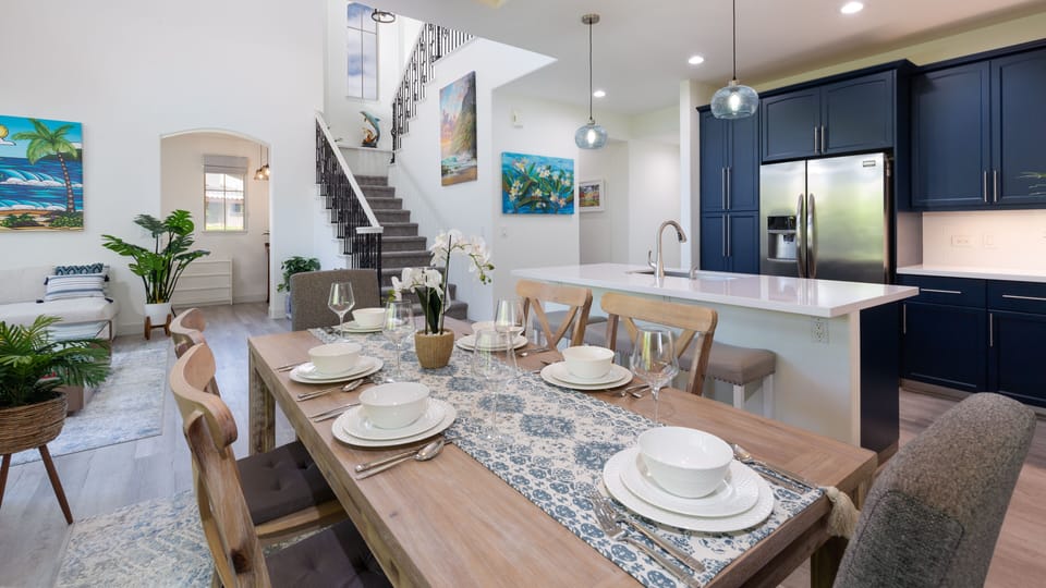 Table for six in the dining room with additional seating at the island