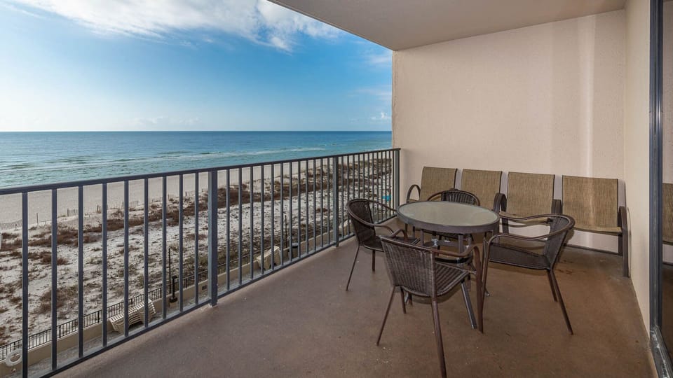 Enjoy meals or drinks at the outdoor table surrounded by comfortable seating and serene views of the beach