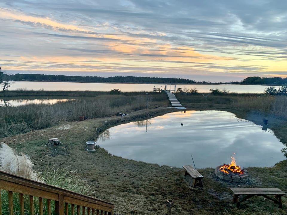Fire Pit and grill next to small pond near deck