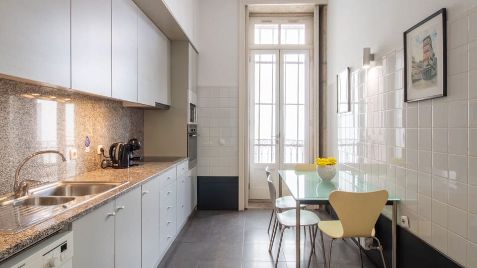 Prepare delicious meals in the bright, fully equipped kitchen, featuring ample counter space and modern appliances for your culinary adventures. The adjacent dining table offers a convenient spot for quick breakfasts or casual dinners, all bathed in natur