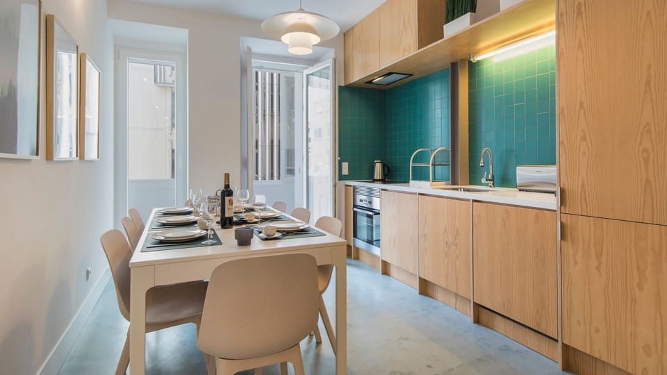 Gather for memorable meals in this bright open-plan dining and kitchen area, where a stylish wooden kitchen with a striking teal backsplash meets a modern dining table set for six. Prepare delicious meals and enjoy leisurely conversations, with natural li