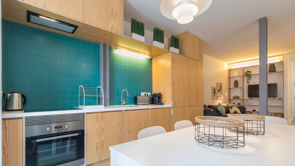 Prepare delicious meals in the well-appointed kitchen, featuring a stylish teal backsplash and modern appliances, then gather with loved ones in the open-plan living area, creating unforgettable memories.