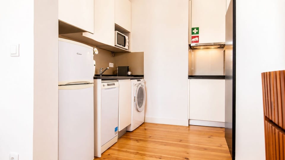 Prepare delicious meals and keep your travel wardrobe fresh with this compact yet fully equipped kitchen and laundry area. The convenient amenities ensure you have everything you need for a comfortable long-term stay. #CompactKitchen #FullEquipped #Laundr