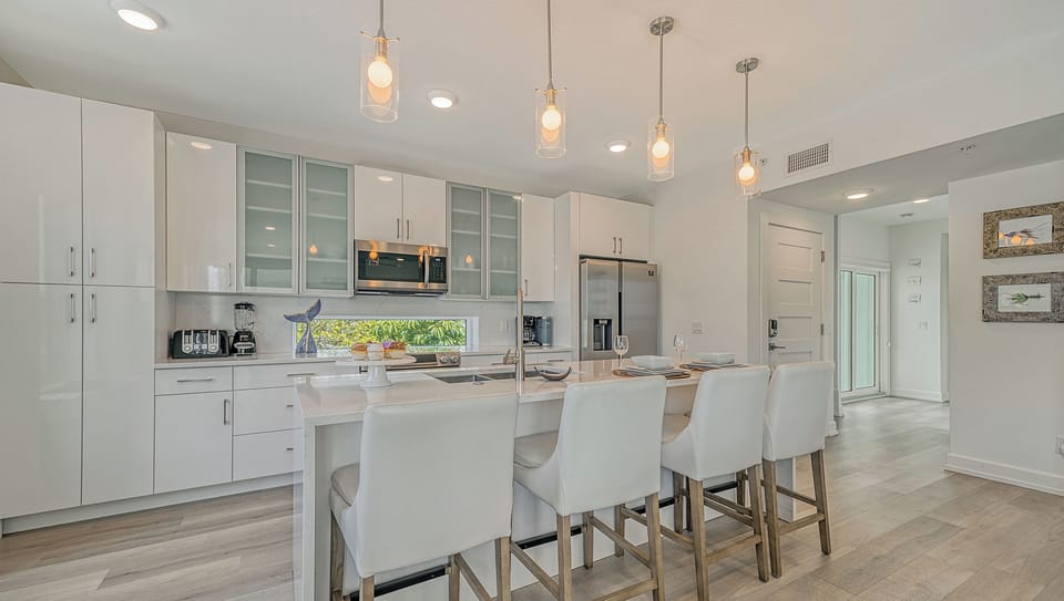 A waterfall-edge island with seating for four anchors the kitchen—ideal for morning smoothies or shared snacks.