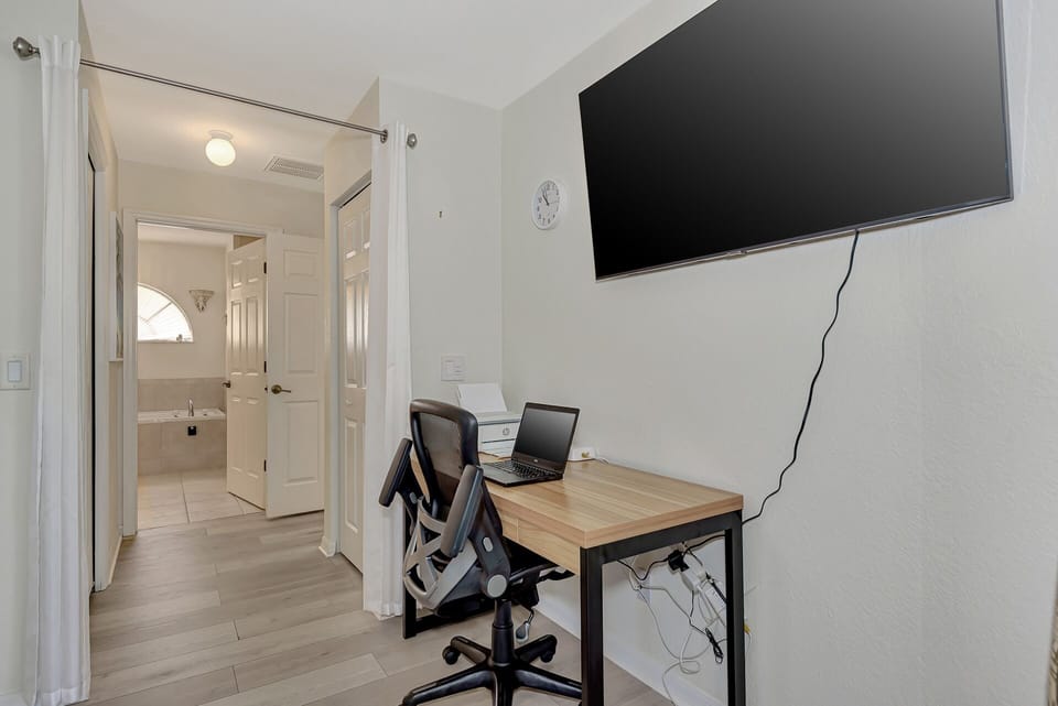 55" Smart TV, desk chair and printer in the master bedroom.
