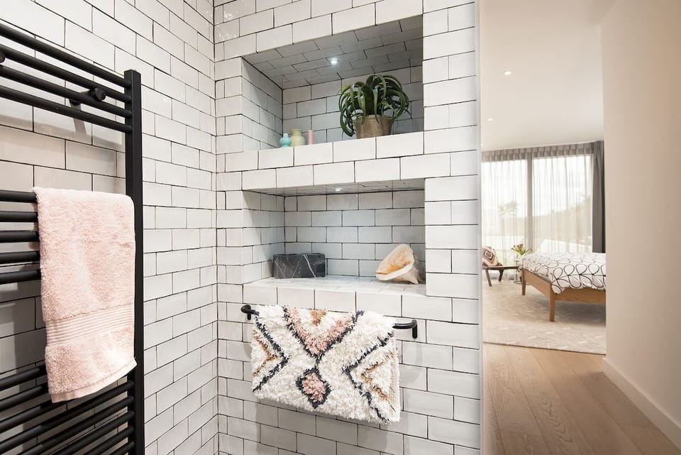 1 The Bay, Coldingham - en suite of bedroom one with matte black heated towel rail and subway-style tiling