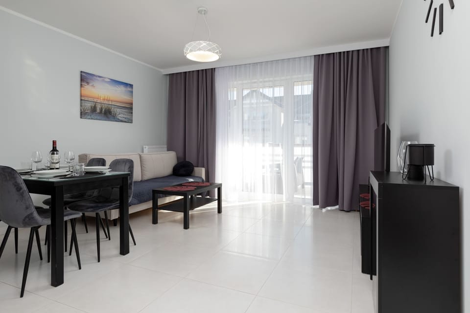 Living room with a comfortable sofa bed, TV, access to the balcony and dining area.