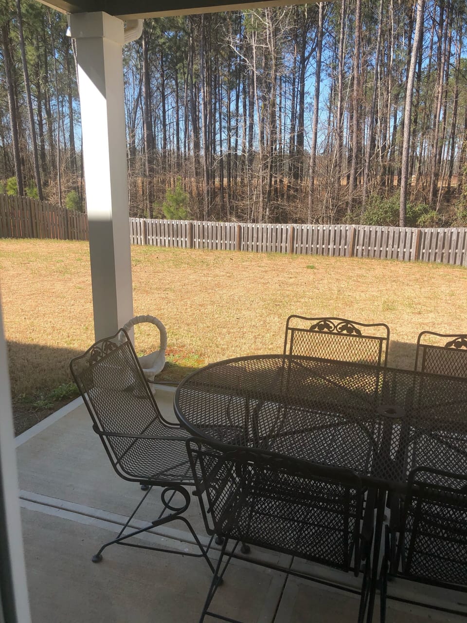 Covered backyard with bar-b-cue grill and patio furniture.