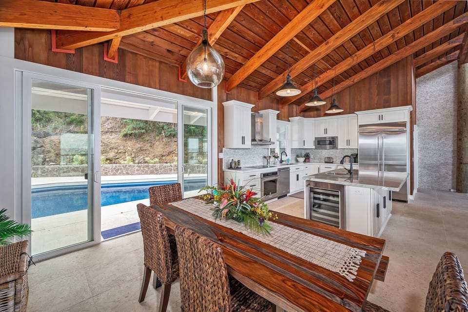 Enjoy pool views while dining together in this seamless kitchen and dining area.