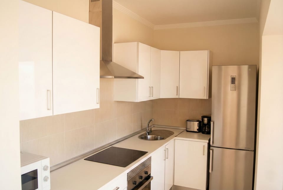 Functional and equipped: bright white kitchen with modern appliances.