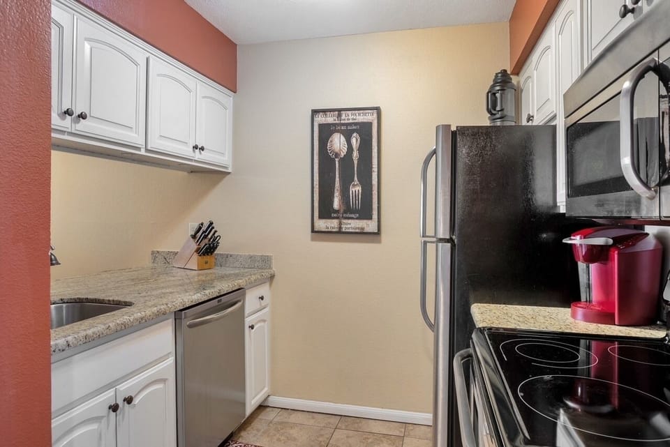 Galley kitchen stocked with dishes, utensils and spices for your stay