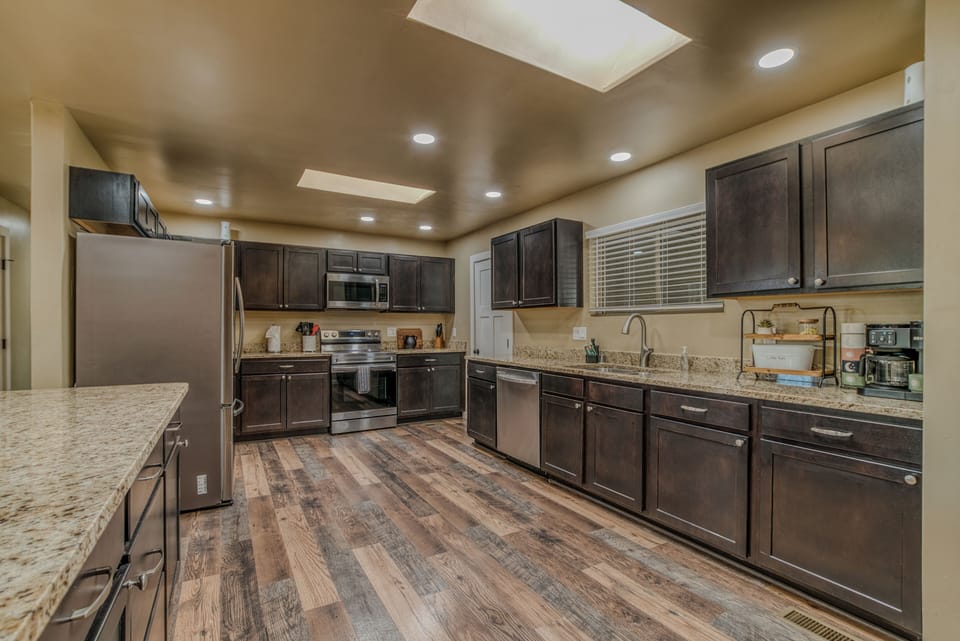 Chef’s Kitchen & Island – A fully equipped kitchen featuring dark wood cabinets