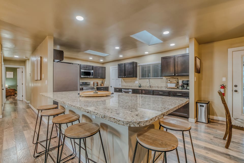 Chef’s Kitchen & Island – A fully equipped kitchen featuring dark wood cabinets