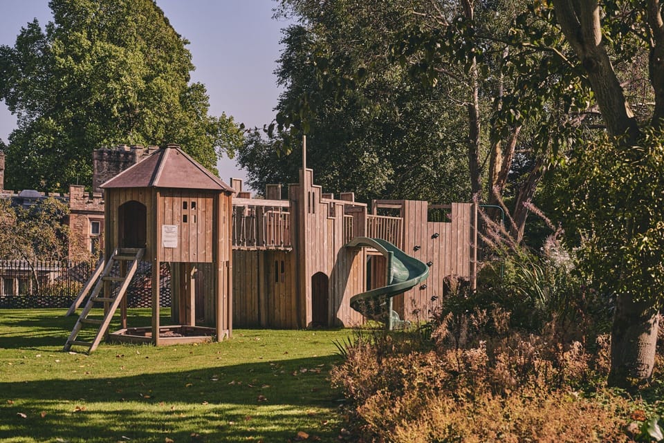 The playground with a climbing wall and slide at Kingfisher Cottage, Welsh Borders