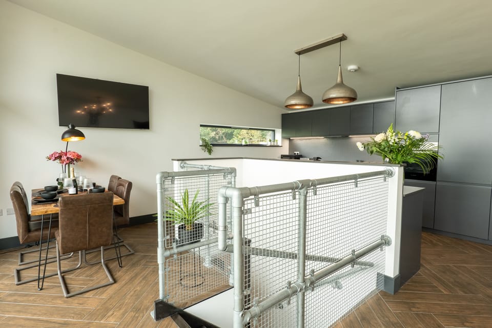 Kitchen and dining area and staircase leading down to two bedrooms and bathroom.