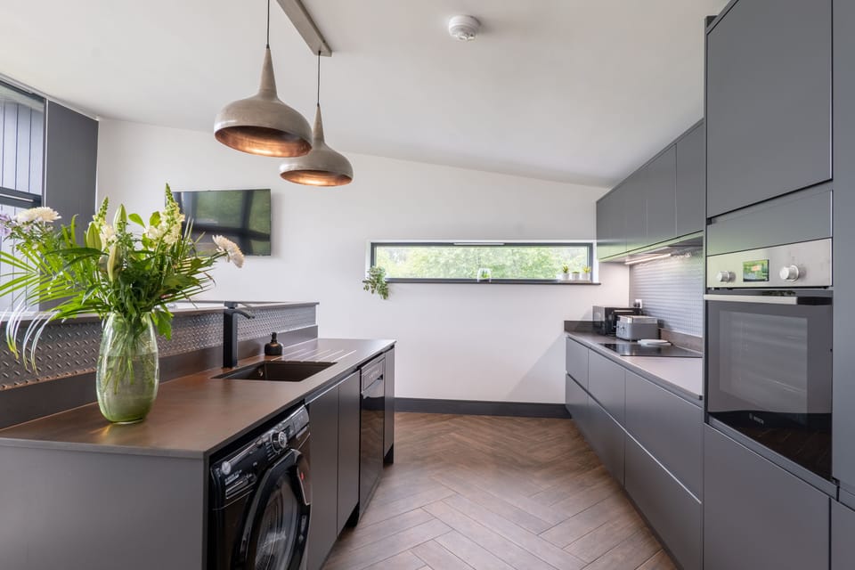 Large kitchen with oven, hob, washing machine, dishwasher and fridge freezer.