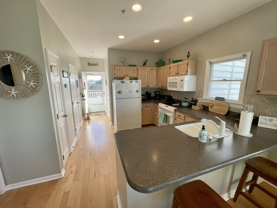 Kitchen area and main entrance facing to the East. A few min walk to the beach!