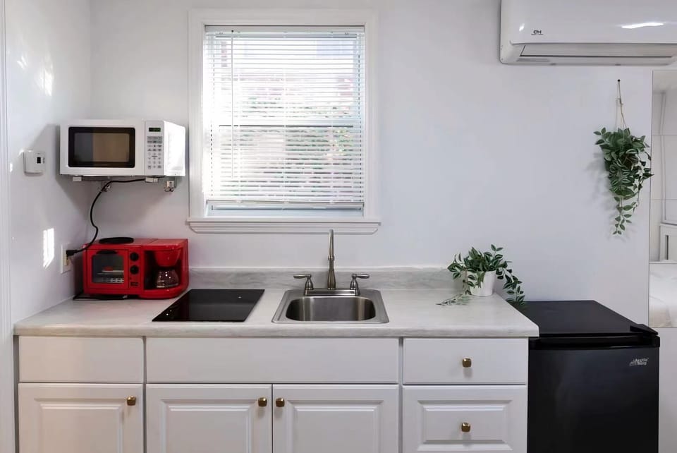 Kitchen with Electric Stove, Microwave, Refrigerator, and Kitchenware.