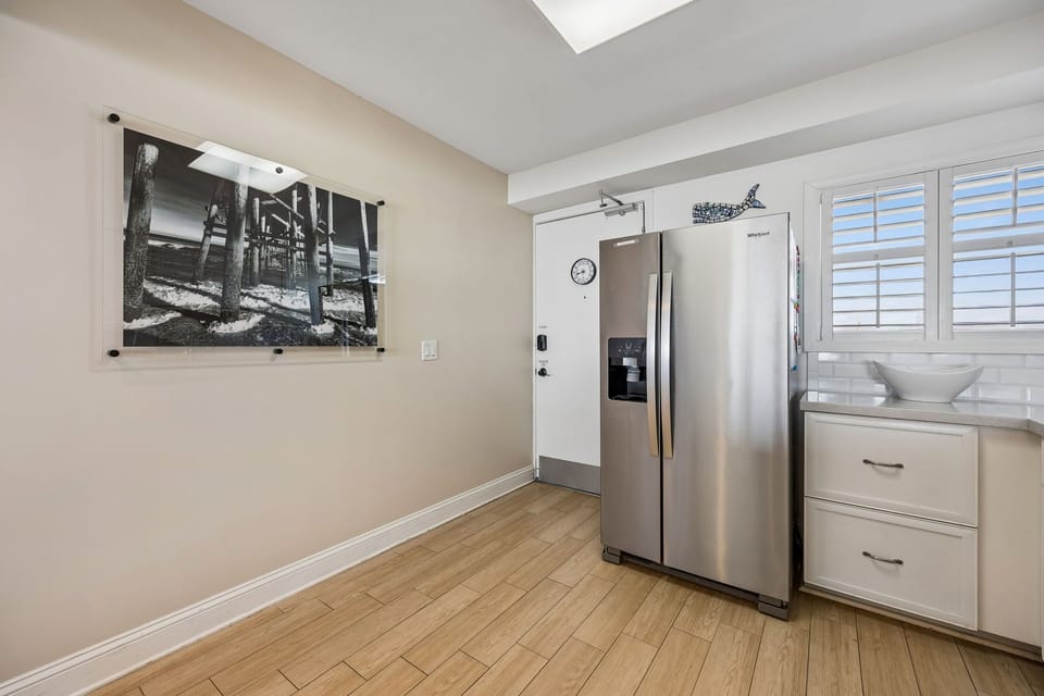 Your private kitchen features sleek stainless steel appliances and warm wood floors, bathed in natural light from plantation shutters—perfect for whipping up your favorite meals in style.