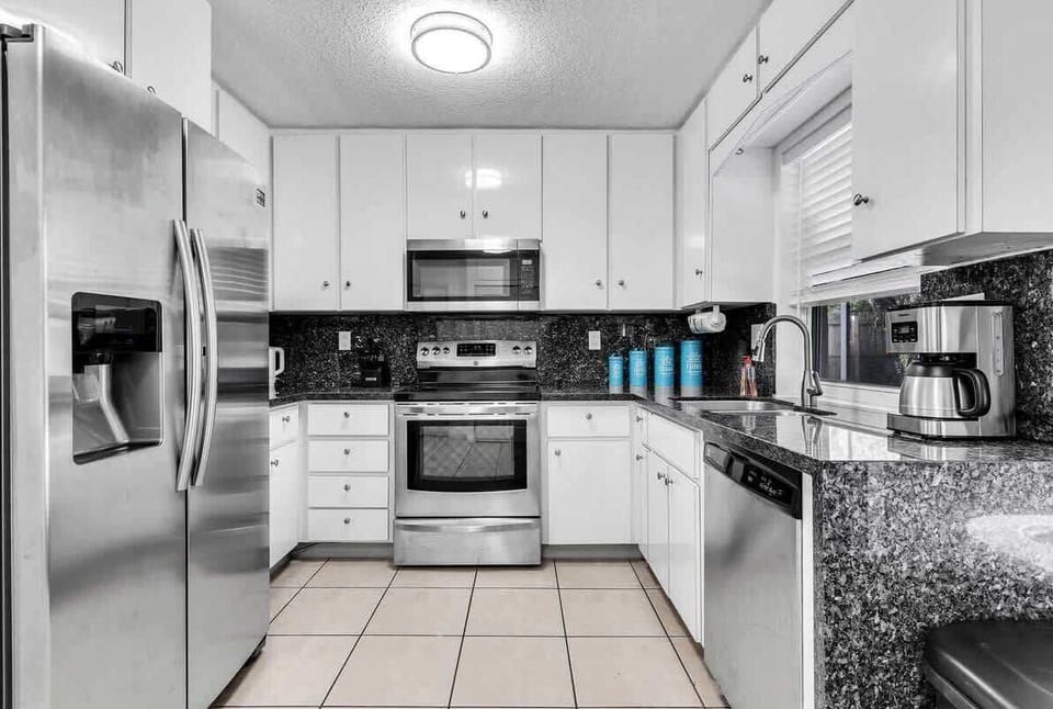 Cook with ease in our modern, fully equipped kitchen featuring stainless steel appliances and ample granite counter space. A clean, bright spot perfect for preparing vacation meals and morning coffee!