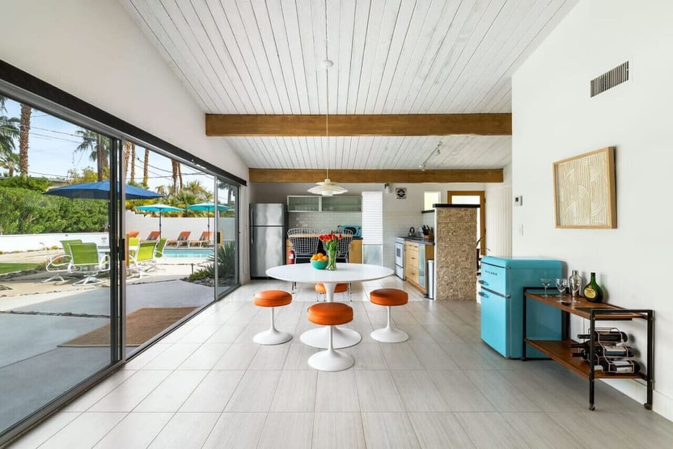 Seamless Indoor-Outdoor Living ☀️🏡 Dine with a view! This sunlit mid-century retreat opens directly to a private backyard oasis—your pool, loungers, and lush palm trees just steps away.