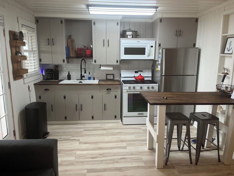 Fully stocked kitchen with gas stove, spices, condiments, pots/pans and cookware