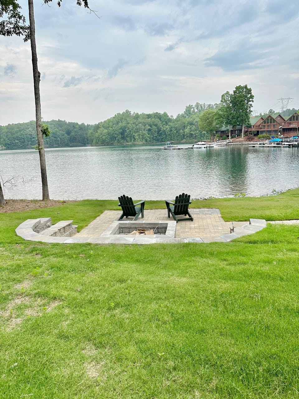 Large green lawn and lakeside patio/firepit area.