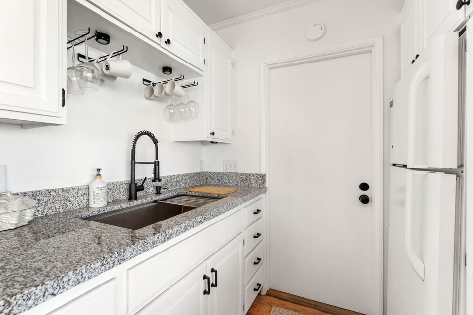 Clean and stocked kitchen with ocean view and access for ocean breeze and sound