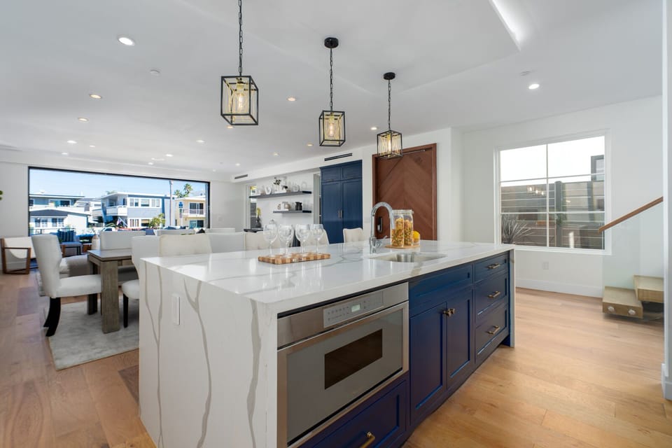 Kitchen island with waterfall countertops and built in microwave. 