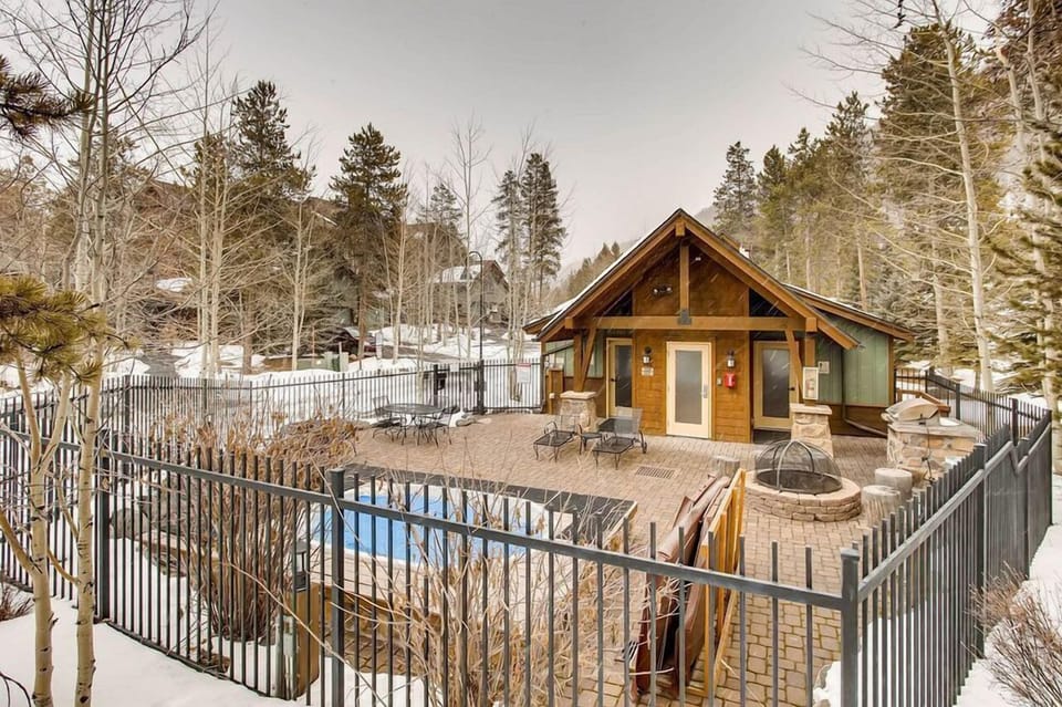 Enjoy relaxation at The Seasons with outdoor hot tubs nestled in a serene, fenced environment amidst a winter wonderland.