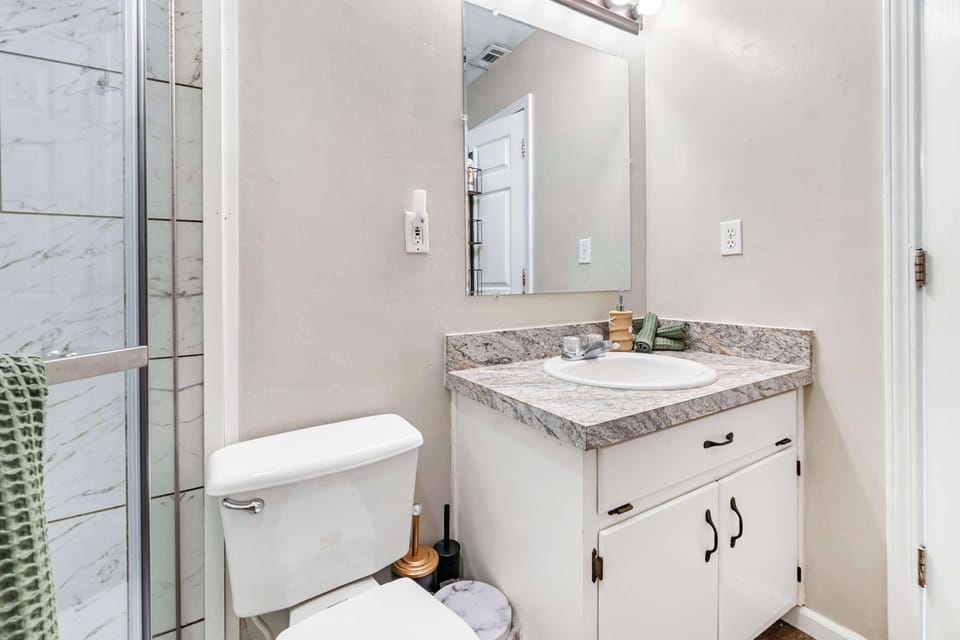Clean bathroom vanity with granite top and mirror.