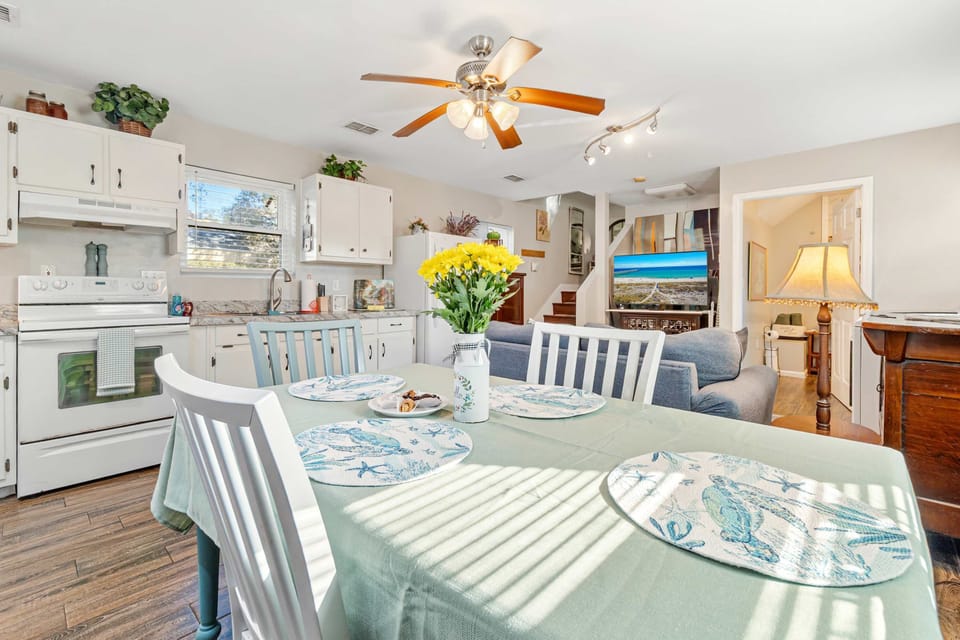 Sunny dining table with coastal placemats in an open-concept home.