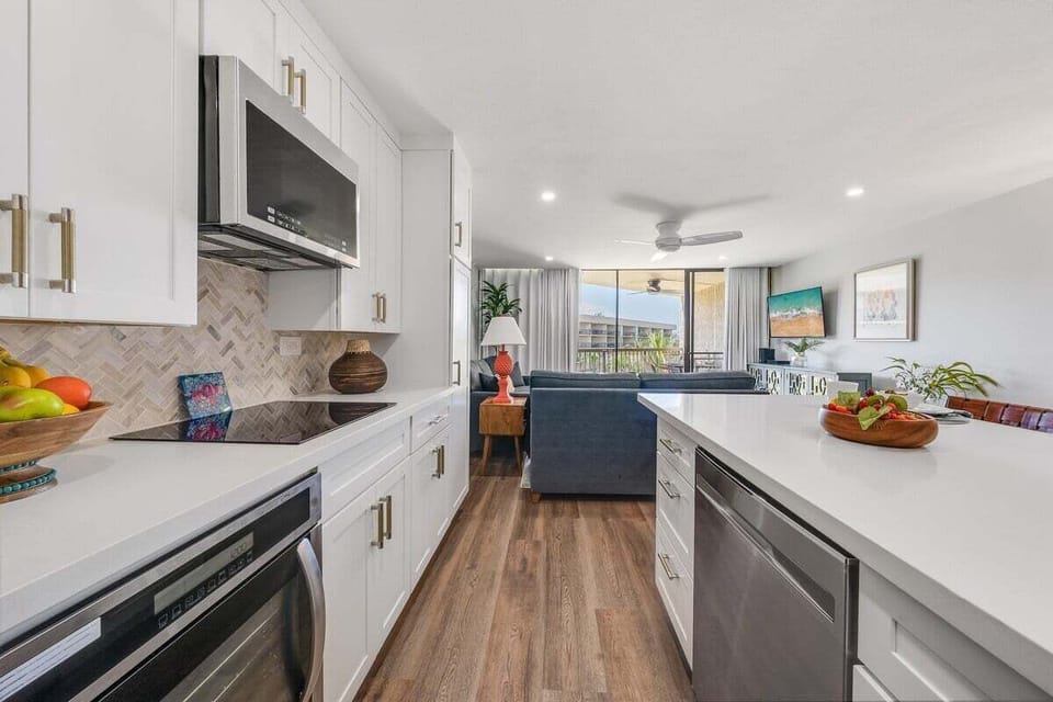 Spacious and fully equipped kitchen features stainless steel appliances and white cabinetry