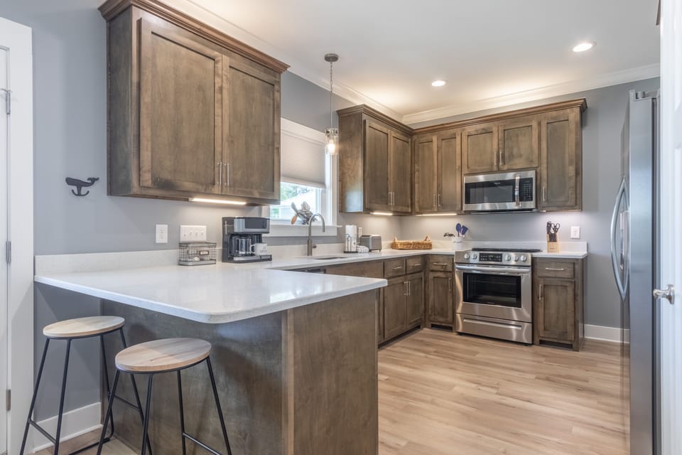 Kitchen - The kitchen boasts stainless appliances and offers all items needed for cooking and serving your meals. An eat in bar is provided with seating for 2!