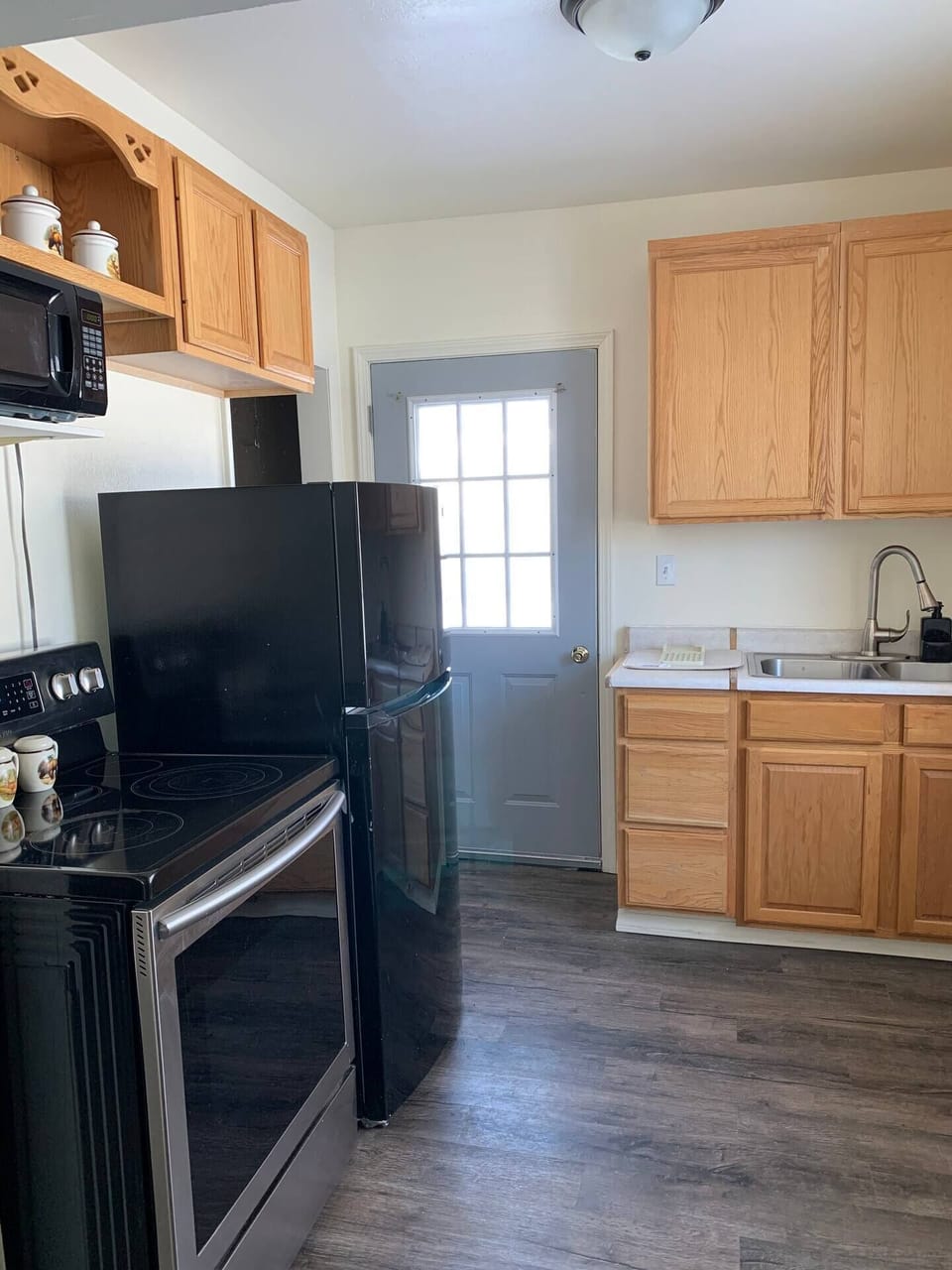 This cozy kitchen includes the essential kitchen gadgets, pots and pans, microwave, and cutlery.