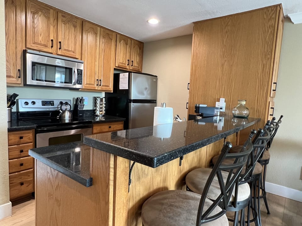 Fully equipped kitchen and bar seating.