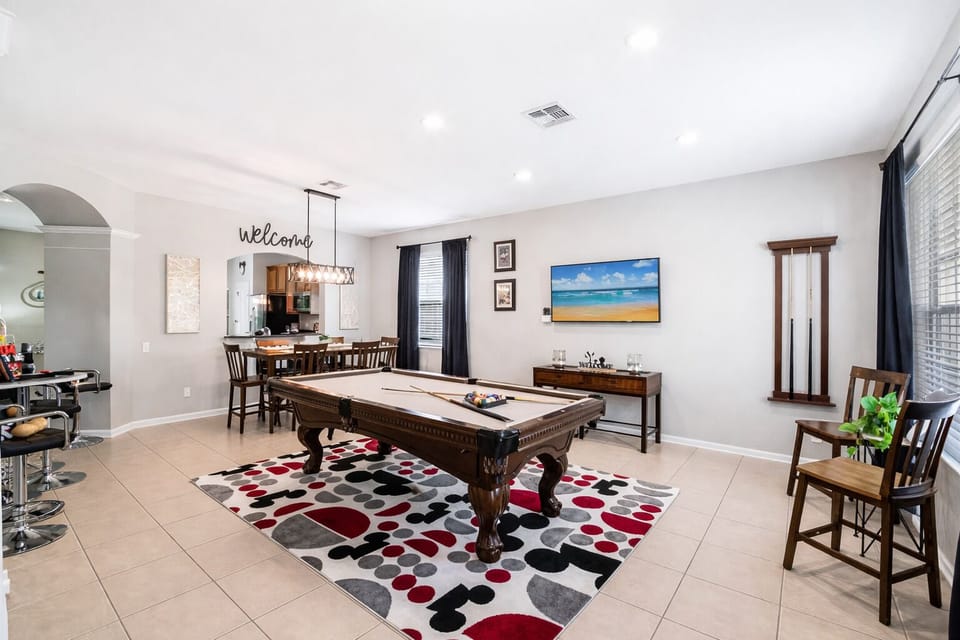 Plenty of room for families to lounge, play and relax with a high end billiard collection pool table in Mickey themed setting.