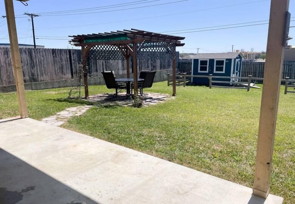 Fully fenced in back yard with pergola
