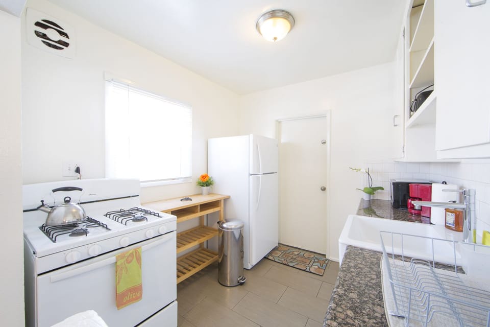 Fully equipped kitchen with stove, oven and fridge.