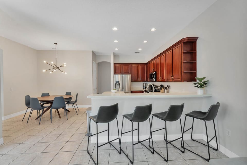 central breakfast bar overlooking kitchen, living room, and patio