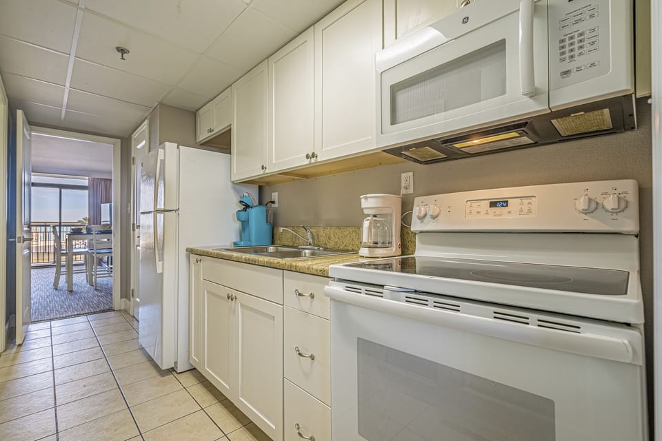 Full kitchen with lots of cooking/dining supplies.