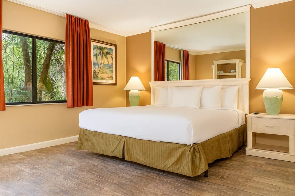Unwind in a sunlit bedroom with crisp linens and calm views.