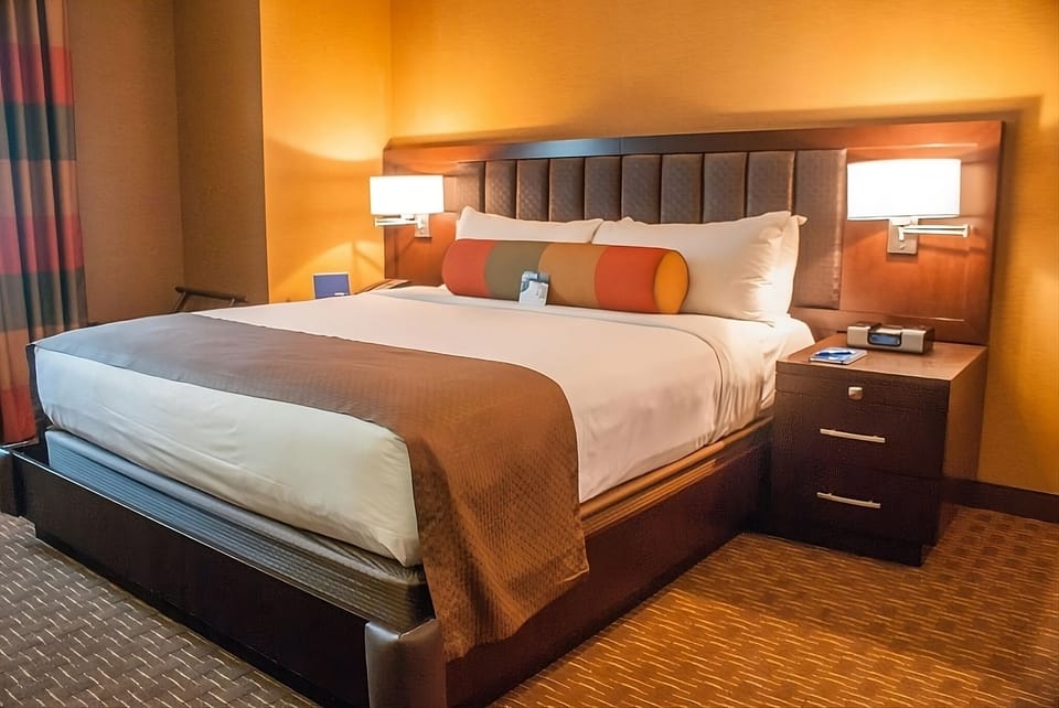 Sink into plush king bedding under warm, soothing lights.