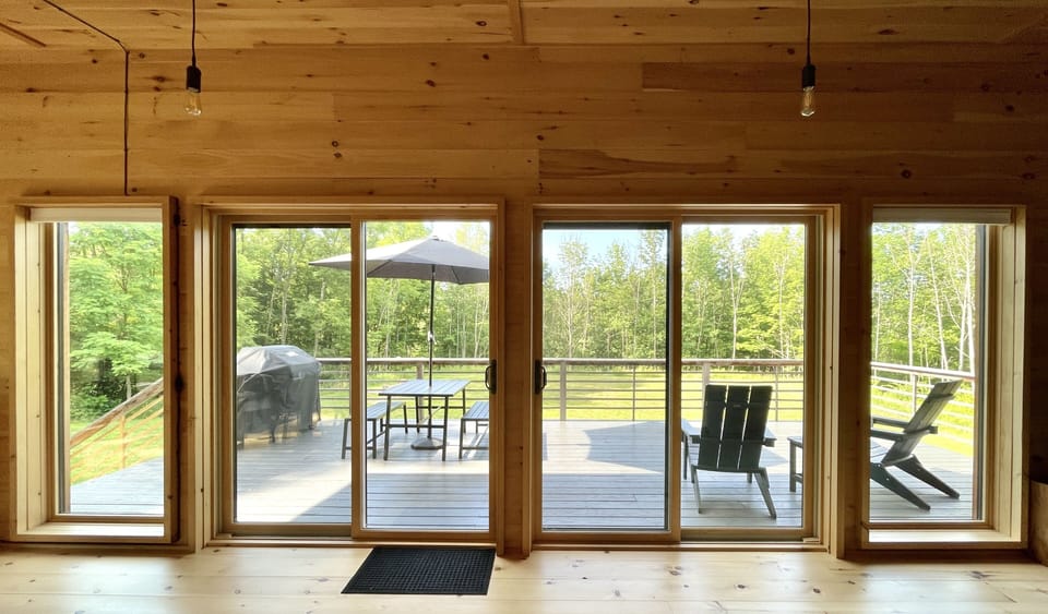 View of the patio from inside  - furnished with table and Adirondack chairs