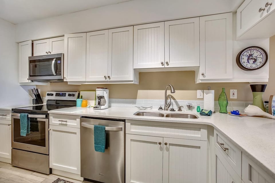 - Cook with ease in the modern kitchen featuring stainless steel appliances and double sink
- White cabinets and spacious counters make meal prep simple and stress free
- Includes dishwasher, microwave, and coffee maker for convenience
