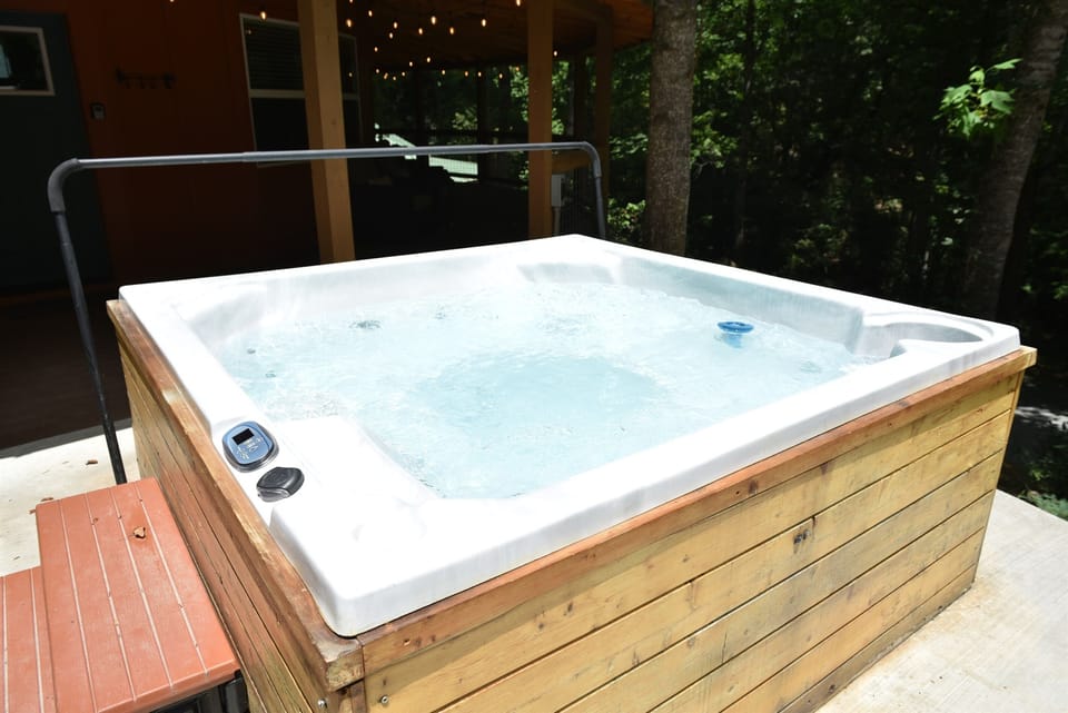 Your private hot tub awaits, jets bubbling and string lights glowing nearby, perfect for soothing tired muscles after a long day of hiking the trails.