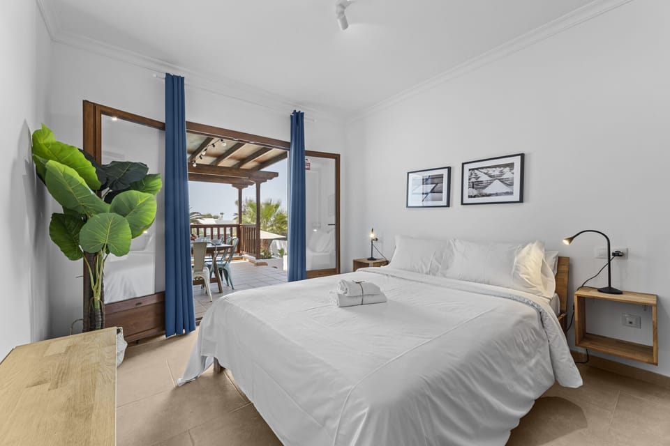 Wake up with views: bright bedroom with terrace access to start the day with energy.